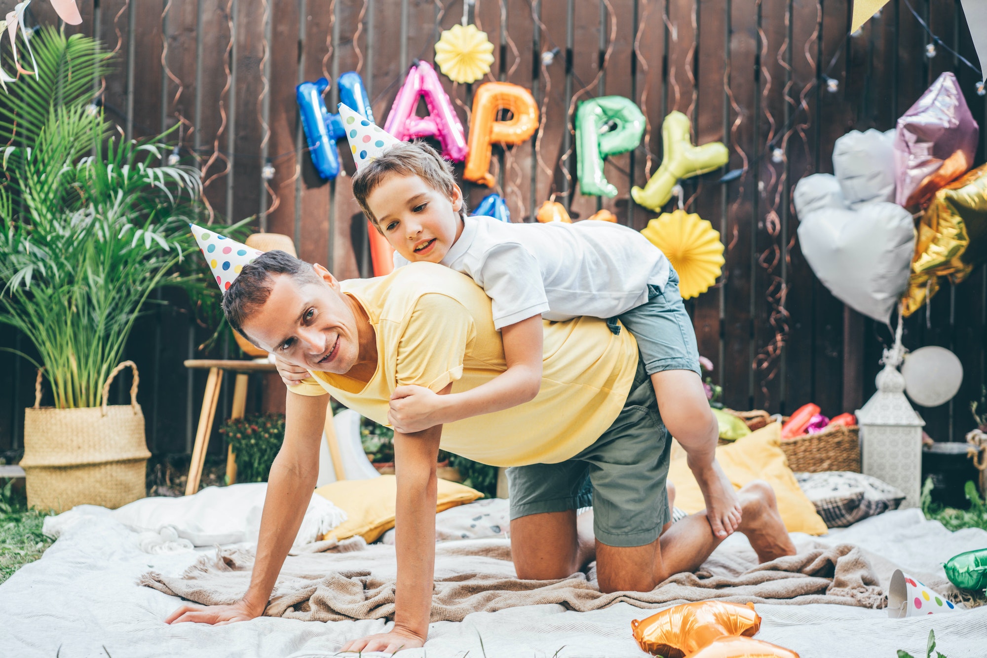 Father and son have fun and playing together at funny birthday celebration