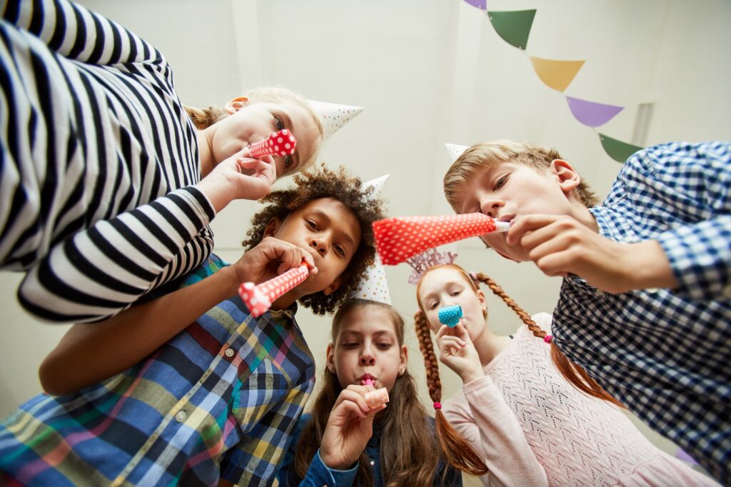 Group of Children Blowing Party Horns