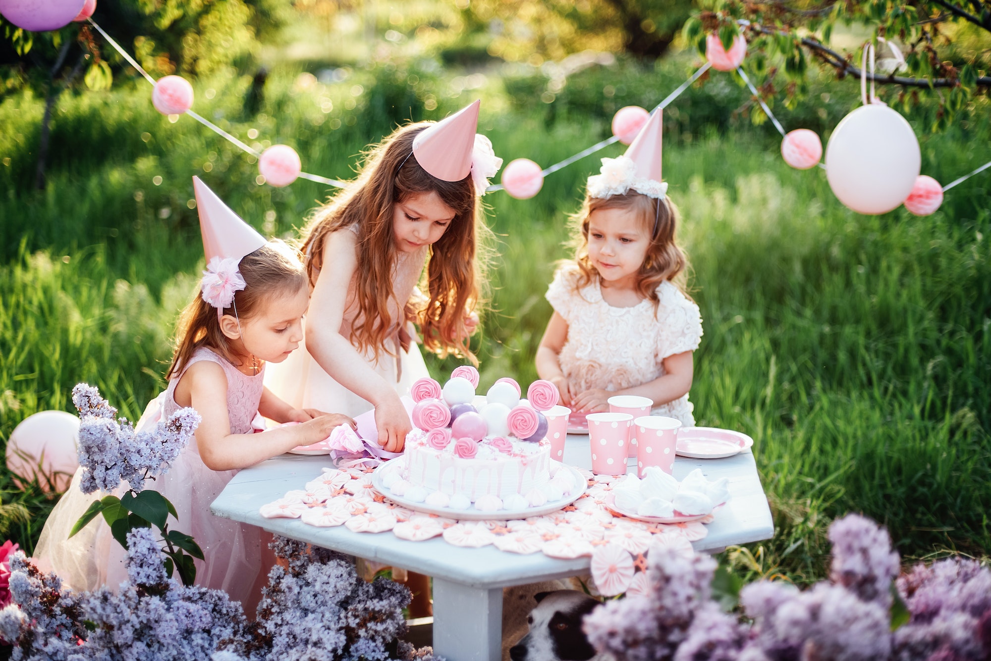 Summer outdoor kids birthday party. Group of happy Children celebrating birthday in park